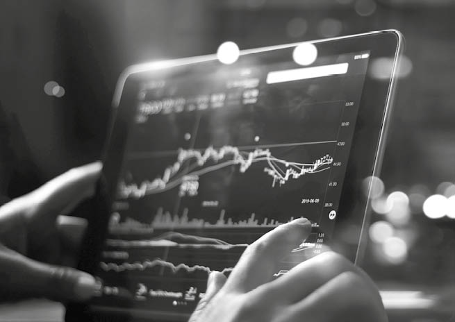 Businessman checking stock market data on tablet on night background